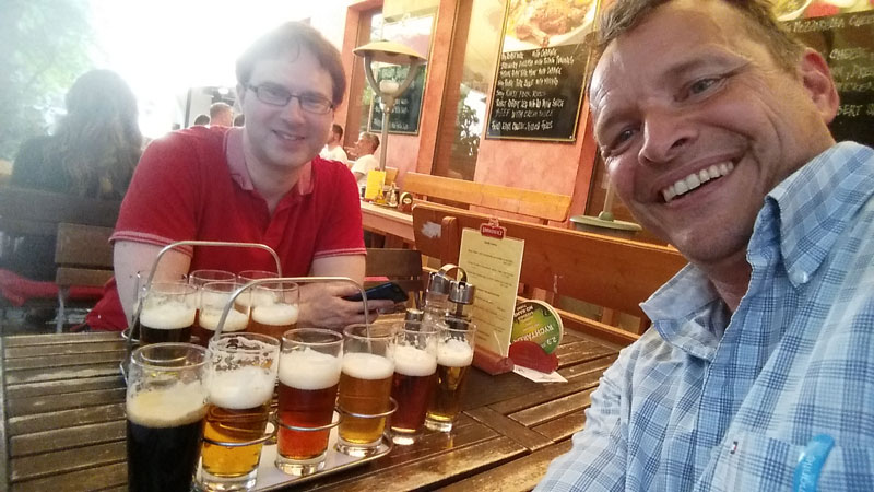 two guys drinking flights of beer in prague