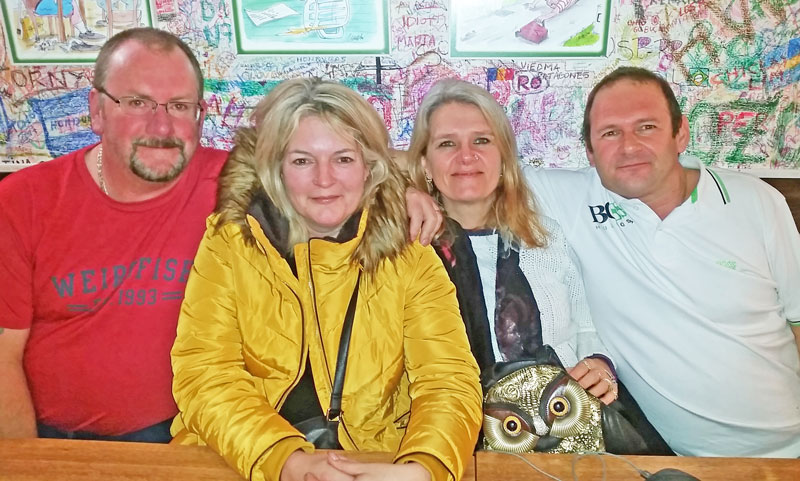 two couples in a pub with graffiti on the wall