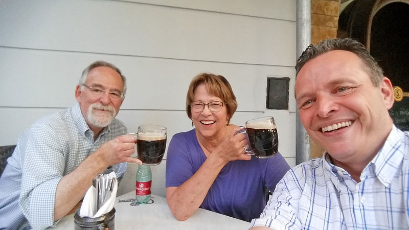 couple sitting down drinking dark beer in prague